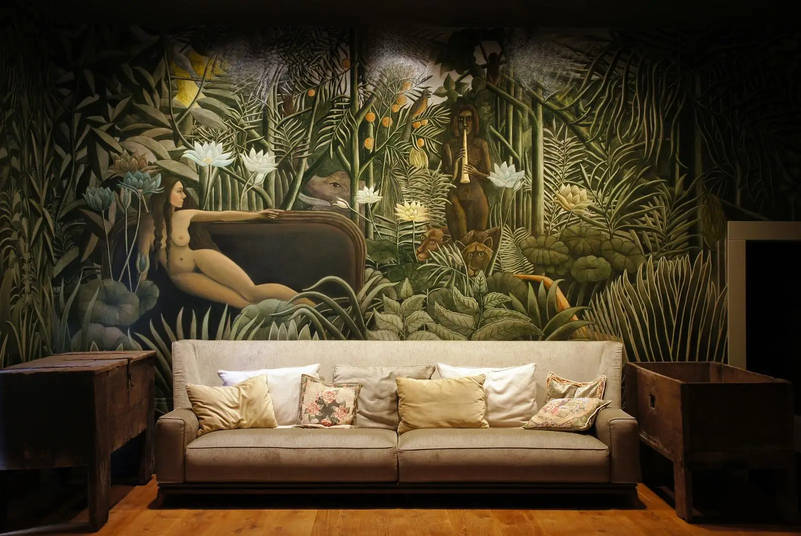 Sofa przed egzotyczną muralem dżungli z bujną zielenią i motywami dzikiej przyrody w luksusowej aranżacji wnętrz w Gdańsku